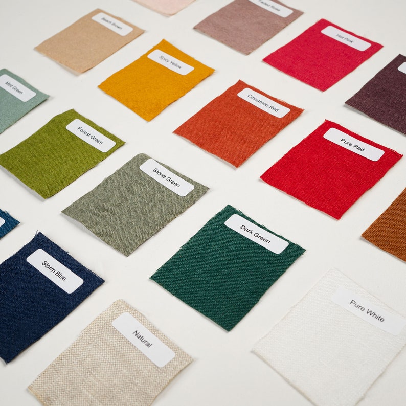 May include: A collection of fabric swatches in various colors, including red, green, blue, yellow, and white. Each swatch has a label with the color name printed on it.