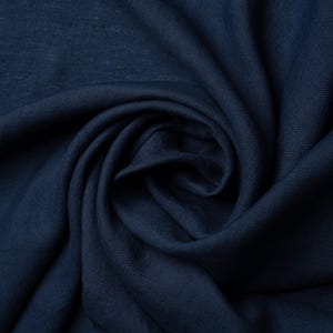 Pu&ograve; includere: Primo piano di un tessuto di lino blu scuro, che mostra la sua trama e il suo drappeggio.