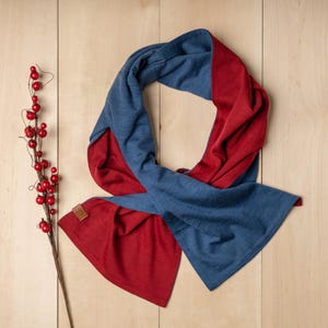 May include: A reversible scarf in blue and red. The scarf is made of a soft, comfortable material and is perfect for keeping warm in the winter.