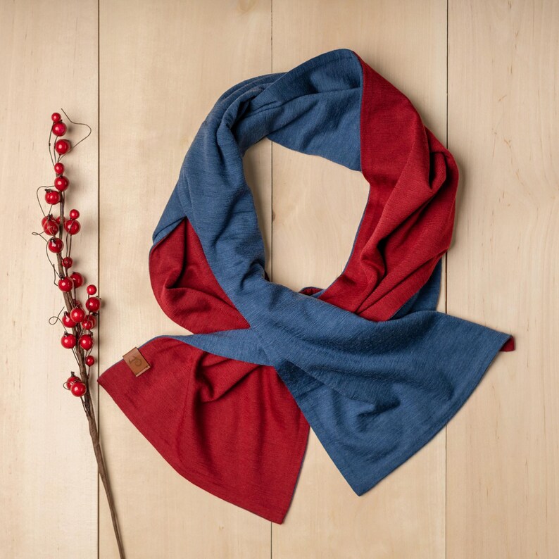 May include: A reversible scarf in blue and red. The scarf is made of a soft, comfortable material and is perfect for keeping warm in the winter.