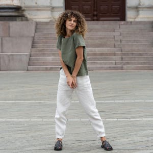 The model wears the EMMA linen t-shirt blouse in stone green