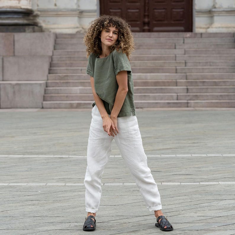 The model wears the EMMA linen t-shirt blouse in stone green