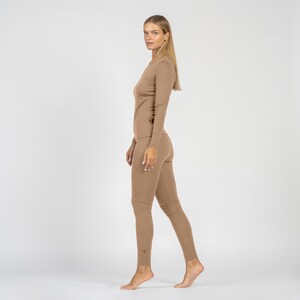 Woman wearing a beige bodysuit on a white background