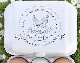 May include: A white egg carton with a black and white illustration of a hen and a calendar showing the months of the year. The text reads "Hand gathered, locally laid eggs were collected on". Three eggs are in the carton, one brown, one blue, and one white.