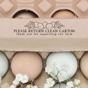 May include: A carton of brown eggs with white flowers on top. The carton has the text "PLEASE RETURN CLEAN CARTON thank you for supporting our farm".