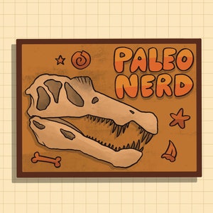 May include: A brown rectangular sign with a cartoon dinosaur skull and the text "Paleo Nerd". The sign has a brown frame and a light brown background. There are also cartoon drawings of a seashell, a starfish, a bone, and a small sail.
