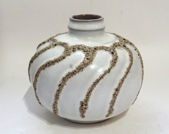 Könnte beinhalten: Weiße Keramikvase mit braunem, gesprenkeltem Design. Die Vase hat einen runden Körper und einen schmalen Hals.