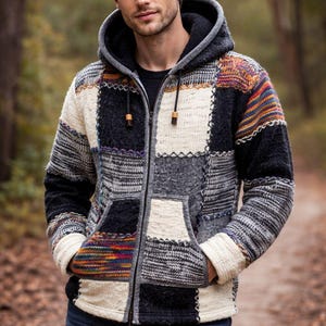May include: A patchwork hooded jacket with a zip fastening and two front pockets. The jacket features a mix of grey, black, white, and colourful patterned panels. The hood is lined with a darker fabric, and the jacket has wooden toggles on the zip.