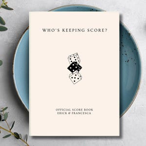 May include: A cream-colored score book with the text WHO'S KEEPING SCORE? at the top and OFFICIAL SCORE BOOK ERICK & FRANCESCA at the bottom. The center features a vertical graphic of three dice, with a black die between two white dice.