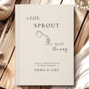 May include: A cream-colored hardcover book with black text and line art. The cover reads: a little SPROUT is on the way, LEAVE A MESSAGE FOR FUTURE PARENTS, EMMA & JAKE. A line drawing of a watering can pouring water onto a small plant is centered.