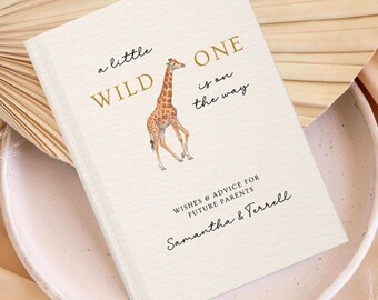 May include: A cream-colored book with a giraffe illustration and gold text that reads: a little WILD ONE is on the way. Below the giraffe, the text reads: WISHES & ADVICE FOR FUTURE PARENTS, followed by the names Samantha & Terrell.