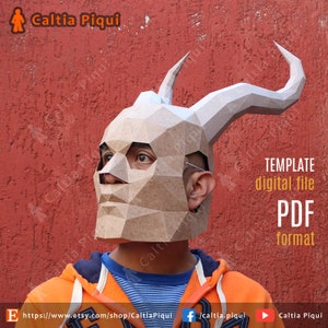 May include: A person wearing a brown paper mache mask with horns. The mask is a template for a digital file in PDF format. The text "Caltia Piqui" is visible on the image.