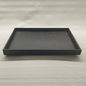 May include: A black rectangular tray with a textured surface.