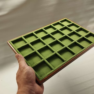 Könnte beinhalten: Ein Tablett aus Holz mit 25 Fächern, die mit grünem Filz ausgekleidet sind. Das Tablett ist perfekt zum Organisieren kleiner Gegenstände.