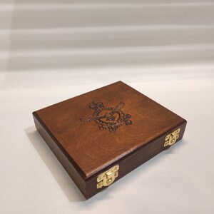 Peut inclure: Une boîte en bois avec un couvercle à charnières et des fermoirs en laiton. Le dessus de la boîte est gravé d'un blason représentant un aigle ailé et le texte "Royal Air Force"