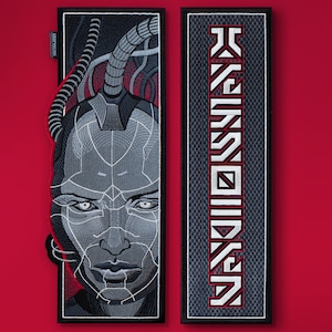 May include: Two rectangular patches. One features a detailed grayscale portrait of a cyborg with intricate line work. The other patch displays the word "KASSDON" in a stylized, vertical font with red accents. Both patches have a black border.
