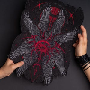 May include: A large black embroidered patch featuring a central red eye surrounded by multiple grey feathered wings. The design includes red geometric accents, small red stars, and the text "I'LL RISE ABOVE ALL THE PAIN, I'LL FIND MY LIGHT" arched across the top.