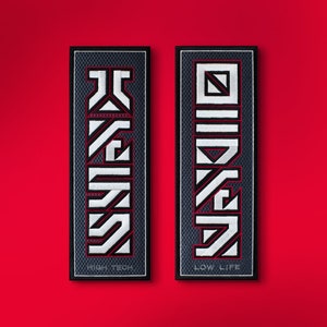 May include: Two black and white embroidered patches with geometric designs. The left patch says "HIGH TECH" and the right patch says "LOW LIFE".