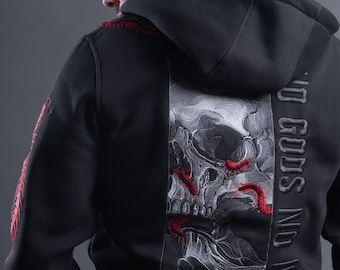 May include: A black hooded sweatshirt featuring a large embroidered graphic on the back depicting a detailed skull with red centipedes. The text NO GODS NO MASTERS is embroidered vertically in black thread. Red centipedes also appear on the sleeve.