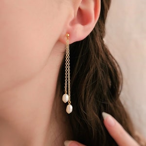 May include: Gold chain earrings with two white pearl drops.