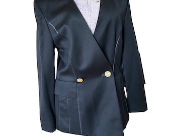 May include: A black blazer with a double-breasted design. The blazer features gold-colored buttons and a notched lapel. The jacket is displayed on a mannequin.