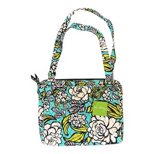 May include: A square-shaped handbag with a floral pattern in white, black, and green on a turquoise background. The bag has two handles and a small green tag. The bag is quilted.
