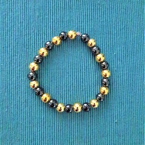 Pulsera de perlas de piedra hematita gris natural y oro 19 cm