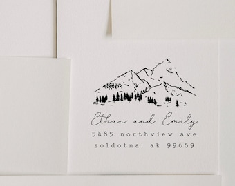 May include: Black and white illustration of a mountain range with trees. Text below reads "Ethan and Emily 5485 northview ave soldotna, ak 99669"