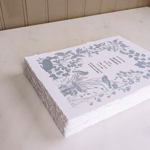Puede incluir: Una pila de tarjetas de papel blanco con un dise&ntilde;o floral azul y el texto "Brooks Edward naci&oacute; el 03.31.23 7 lbs 8 oz bienvenido con amor por Brian y Julie"