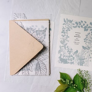 Puede incluir: Una tarjeta de invitaci&oacute;n azul claro con un borde floral y una ilustraci&oacute;n de un conejo blanco. La tarjeta dice "Introducing Peter Benjamin born 05.22.23 8 lbs 1 oz 17:39 am".