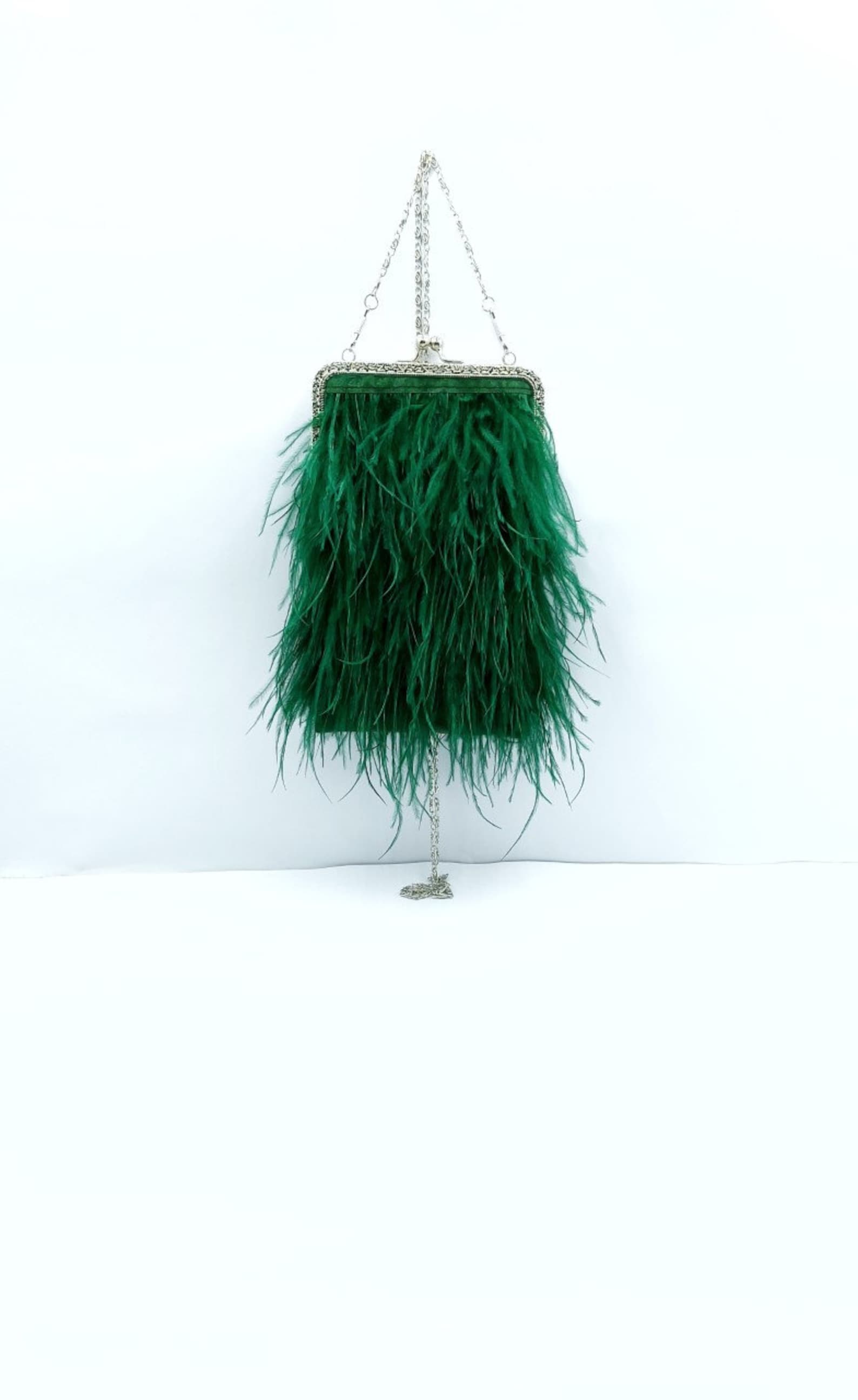 Delicate green feathered bag, sewn onto velvet. Silver clasp closure and delicate chain handle.