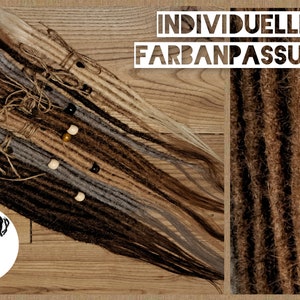 May include: A variety of brown, blonde, and gray synthetic dreadlocks with beads. The text "INDIVIDUELLE FARBANPASSUNG" is visible in the image.