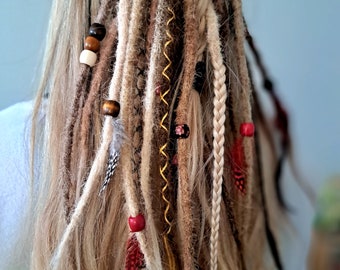 May include: Blonde hair styled with a variety of dreadlocks, braids, and beads. The dreadlocks are brown, blonde, and white, and the beads are red, brown, and white.