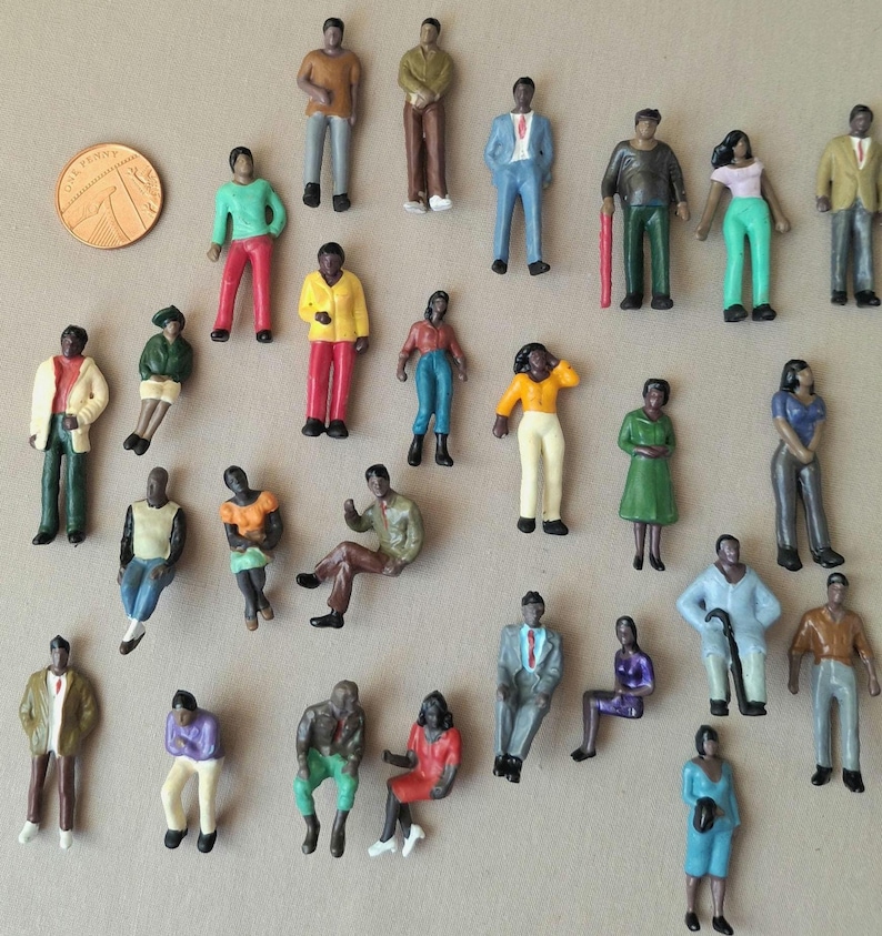 Puede incluir: Una colecci&oacute;n de figuras en miniatura que representan a personas en varias poses y atuendos. Las figuras est&aacute;n pintadas en una variedad de colores, incluyendo verde, amarillo, rojo y azul. Se incluye una moneda para la escala.