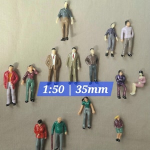 May include: Small model figures of people in diverse poses and attire. The figures are painted with realistic details, including clothing and skin tones. A blue banner displays the text "1:50 | 35mm".