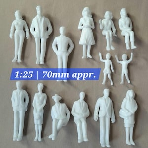 May include: A set of small, white plastic figures in different poses, including standing, sitting, and with arms raised. The text "1:25 | 70mm appr." is visible. These figures are likely for architectural models or model making.