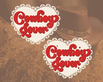 May include: Two white heart-shaped lace designs with the text "Cowboy Lover" in red lettering.