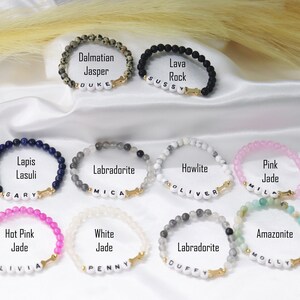 Peut inclure: Plusieurs bracelets de perles de pierres pr&eacute;cieuses, dont le jaspe dalmatien, la roche de lave, le lapis-lazuli, la labradorite, l'howlite, le jade rose, le jade rose vif, le jade blanc et l'amazonite. Chaque bracelet a un charme d'os dor&eacute; et un nom.