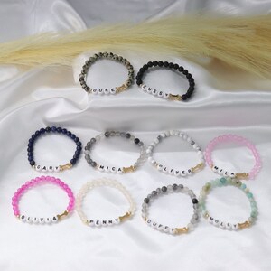 Puede incluir: Diez pulseras de cuentas de colores con dijes de hueso dorado y nombres personalizados, incluyendo Gary, Mica, Oliver, Mila, Olivia, Penny, Duffy, Molly, Duke y Sissy.