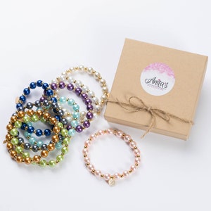 May include: A set of colorful pearl bracelets with gold accents, packaged in a brown box with a pink logo that says "Anita's Accessories".