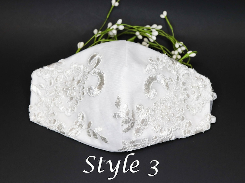 May include: White face mask with delicate lace and pearl embellishments. The mask has a floral design and the text "Style 3" is printed below it.