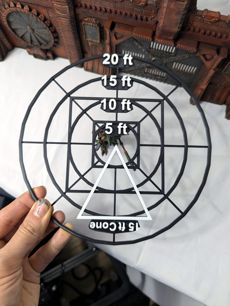 May include: Black plastic template with concentric circles and a triangle. The circles are labeled with measurements in feet: 5 ft, 10 ft, 15 ft, and 20 ft. The triangle is labeled "15 ft cone".
