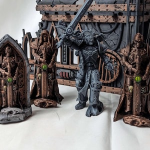 Könnte beinhalten: Vier Miniaturfiguren, drei stehen vor einem Steinbogen, und eine steht vor einer Metallstruktur. Die Figuren halten Schwerter und sind in Braun-, Grau- und Grüntönen bemalt.