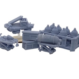 Puede incluir: Un conjunto de seis modelos en miniatura impresos en 3D de color gris de varios carros y cajas de estilo steampunk. Los carros tienen ruedas y una variedad de carga, incluyendo un cañón, una caja y una pila de objetos redondos.