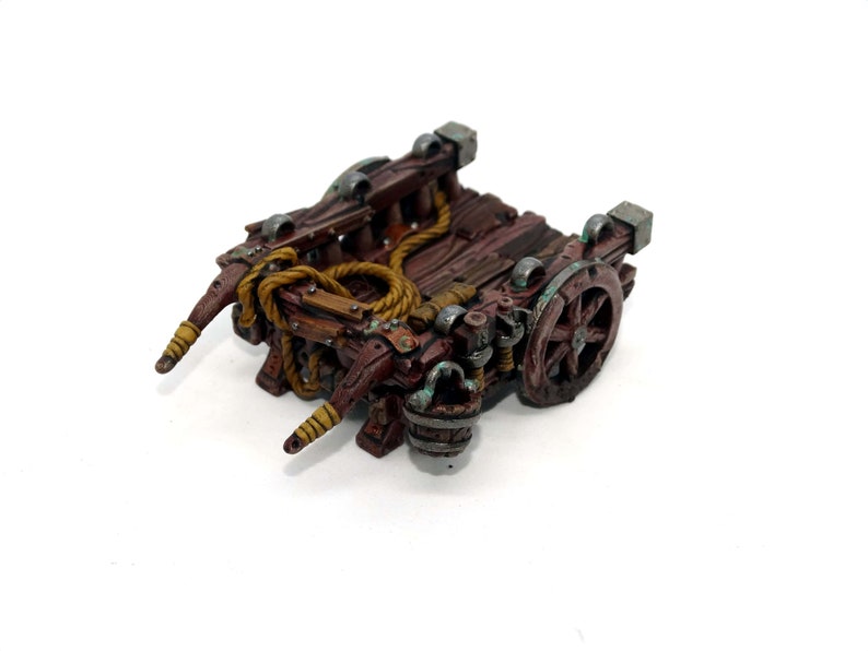 May include: A wooden miniature cart with a rope, a bucket, and a wheel. The cart is painted brown with green and silver accents.