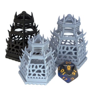 May include: Three 3D printed hexagonal cages, two in gray and one in black, with a blue and black 20-sided die in the center.
