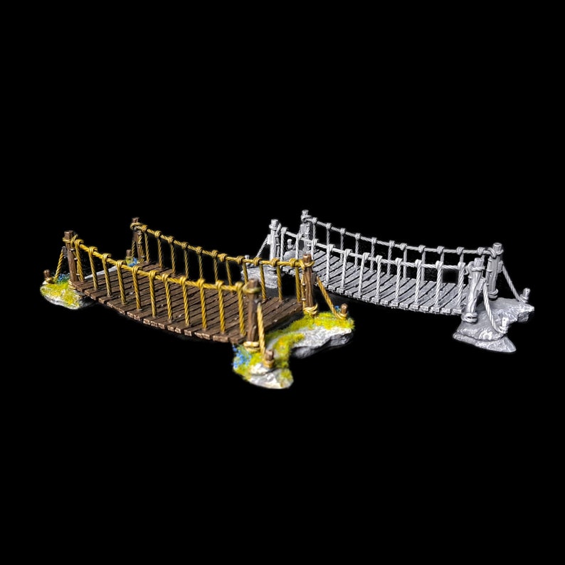 May include: Two miniature rope bridges, one brown with yellow rope and one grey with white rope. Both bridges are made of wood and have stone bases.