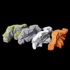 May include: Four different textured rock formations, ideal for model building or miniature gaming. The rocks are gray, white, and orange.