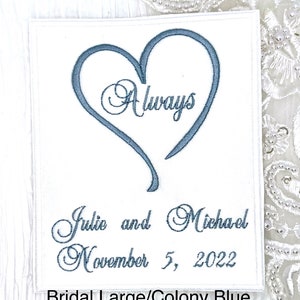 May include: White fabric wedding patch with a blue embroidered heart that says "Always" inside. Below the heart is the text "Julie and Michael November 5, 2022" and the words "Bridal Large/Colony Blue".