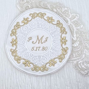 May include: White round ceramic plate with a gold embossed design. The plate has the initials "P M J" and the date "5.17.80" inscribed in gold.